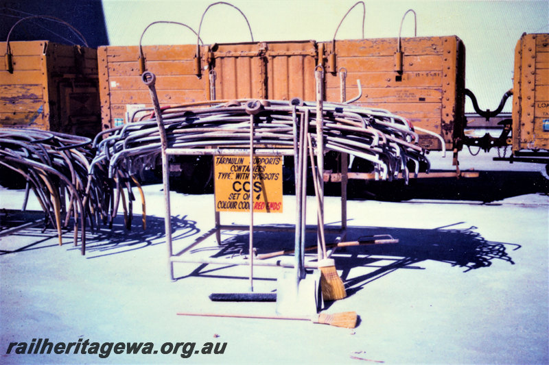 P22864
Racks of tarpaulin supports, with sign, wagons, CSBP Kwinana, view from ground level
