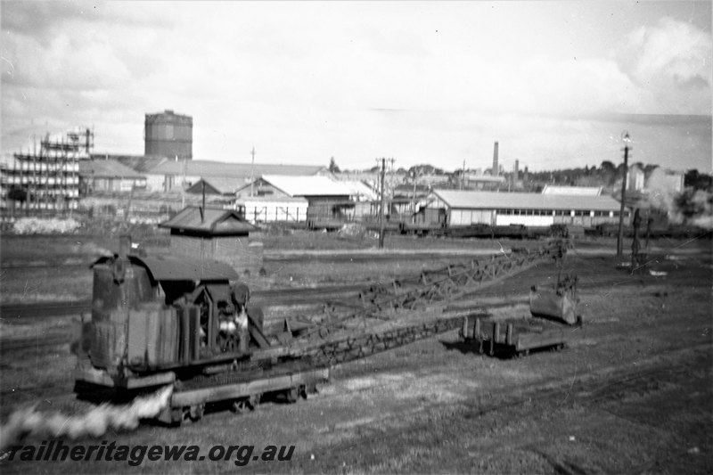 P22879
Six wheel rail-mounted steam crane, sheds, wagons, tracks, gasometer, buildings, East Perth loco depot, ER line, end and side view
