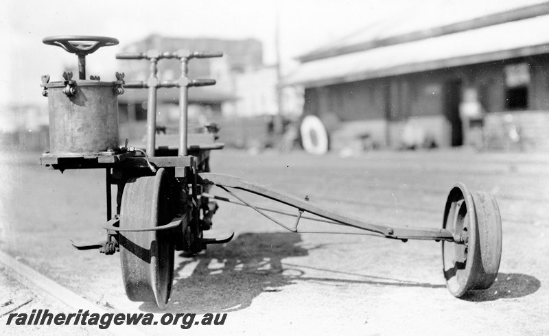 P22903
Rail tricycle, with greaser, water tower, shed in background, front view
