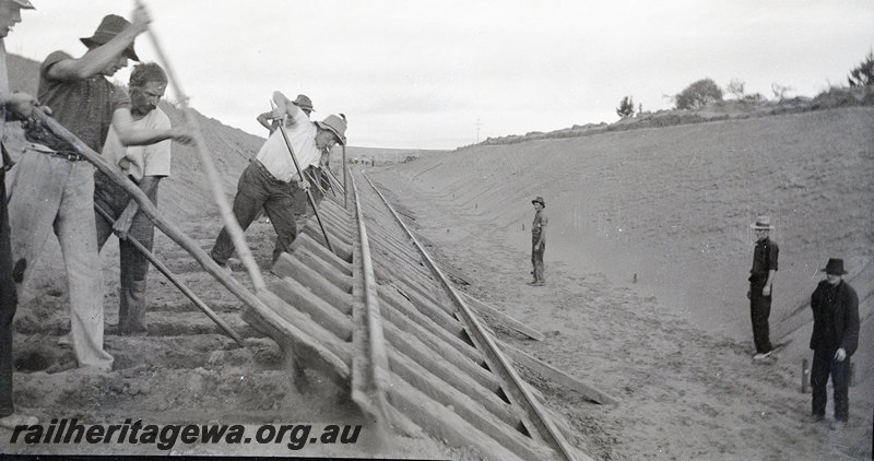 P22910
Regrading & Deviation at Indarra NR line 30 June 1935 1 of 7, gang levering track into cutting, onlookers, ground level view 
