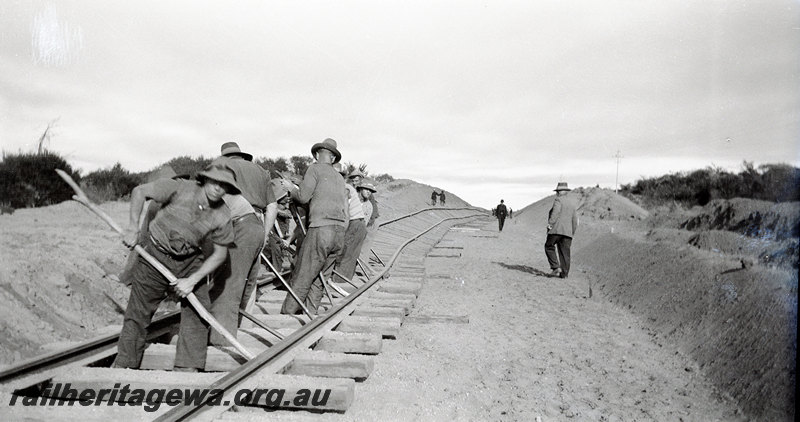 P22911
Regrading & Deviation at Indarra NR line 30 June 1935 2 of 7, gangers levering track into position, overseers, cutting, ground level view
