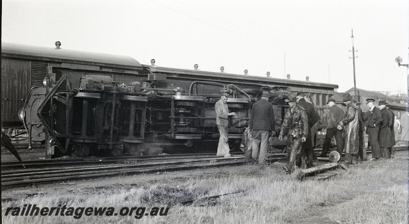 P22922
Derailment of steam locomotive 1 of 3, loco on its side, workers, view of underside of loco 
