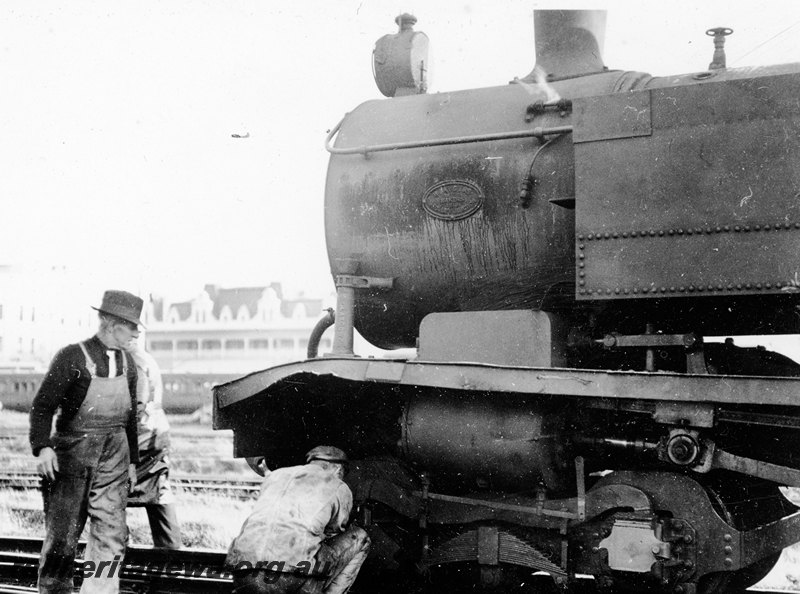 P22924
Derailment of steam locomotive 3 of 3, loco upright, showing damage to front and cylinder, workers, side view of part of loco from trackside 
