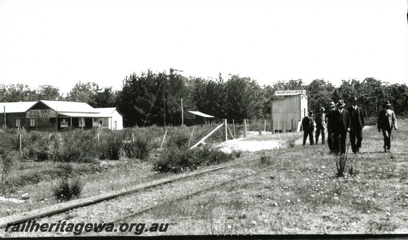 P22939
Railway Hostel, Out of Shed with station nameboard on the roof, group of suited man, Northcliffe, PP line, trackside view, Commisioners tour of the South West
