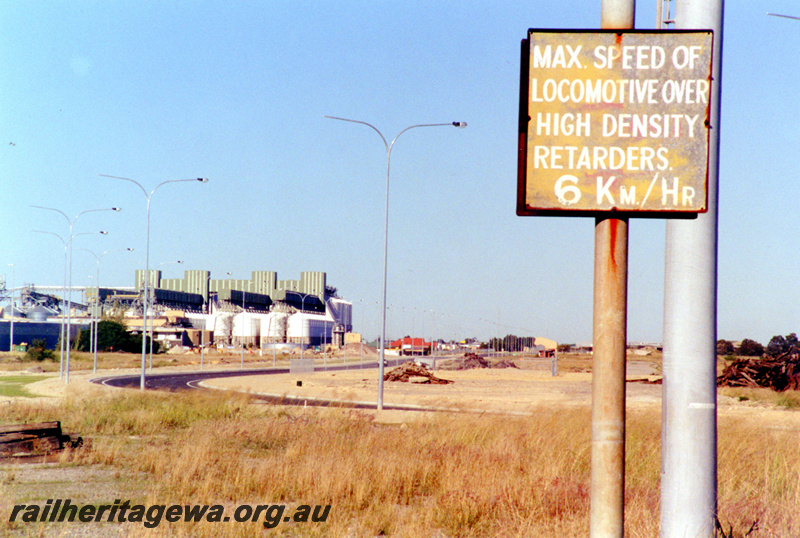 P23104
Forrestfield Hump Yard 4 of 6, hump yard, new road, light poles, industrial buildings in background, locomotive speed limit sign, ground level view
