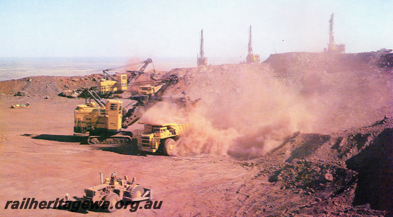 P23107
Mining equipment, dump trucks being loaded, Mount Whaleback iron ore mine, overall view of operations

