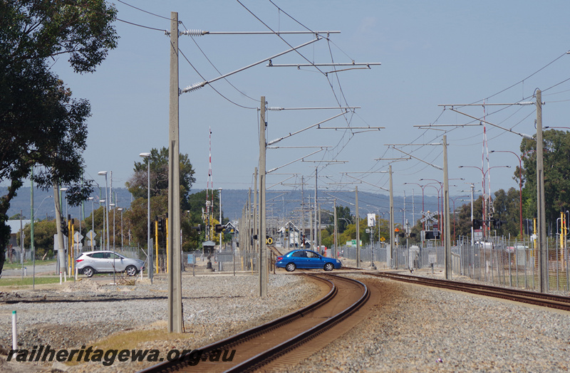 P23211
Level crossing, station in distance, hills in background, Wharf Street, Queens Park SWR line, view from trackside
