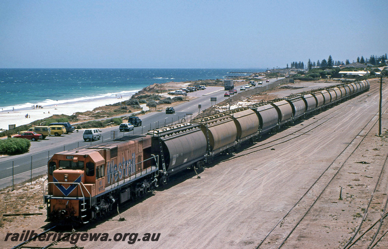 P23219
NB class 1873 on grain train, Leighton, ER line, beach and ocean, front and side view from elevated position 
