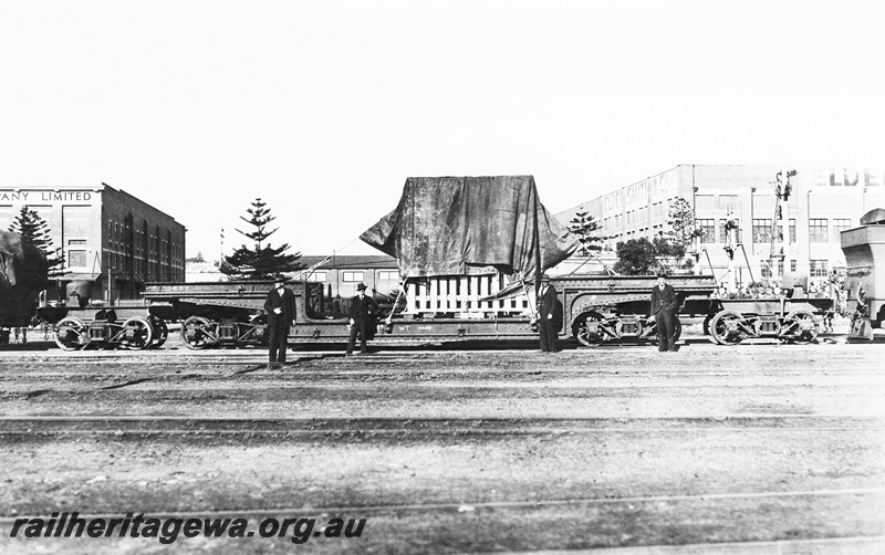 P23270
QX class 2300 trolley (well) wagon ,crated heavy load partly tarped,  Fremantle. ER line. Side view
