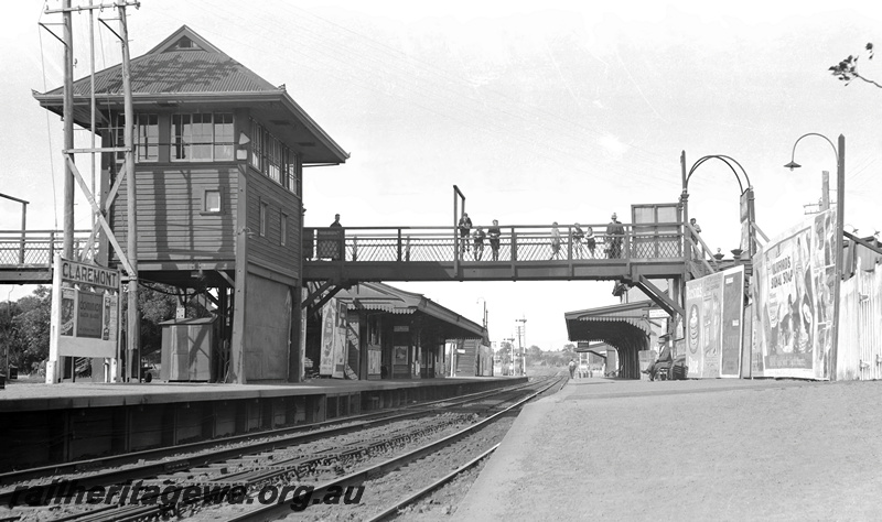 P23281
Claremont Station. View from Fremantle platform looking east. Signal cabin and main footbridge, station buildings on both platforms, signals in background. ER line.
