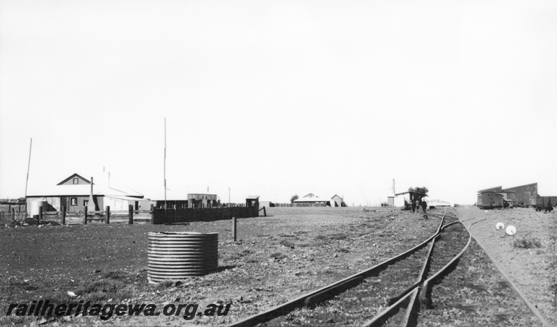 P23329
Station building, goods shed, cheese knobs, houses away from the station, Leonora, KL line, overall view of the location looking down the track
