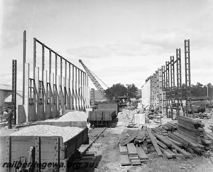 P23331
Shell Forging Annex  building under construction, walls only erected, H class wagons loaded with ballast, steam crane at the end of the buiding site,  Midland Workshops 
