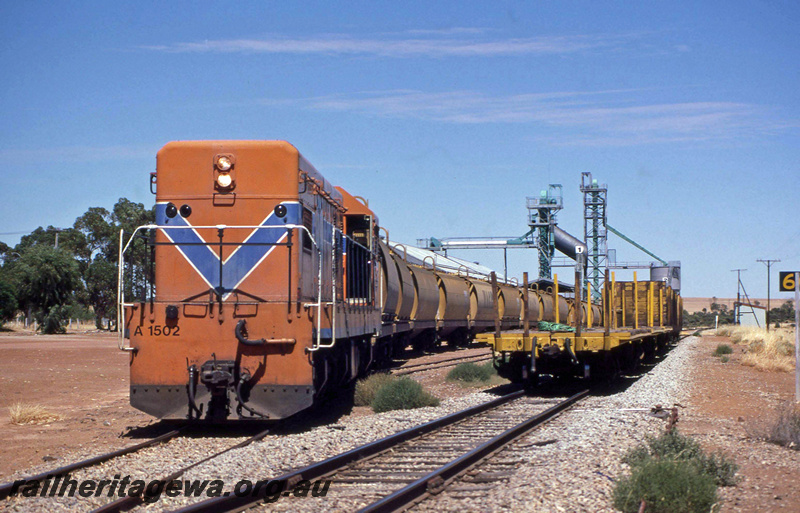 P23381
A class 1502, shunting grain wagons for loading, overhead loader, wheat bin, flat wagon, Minnivale, GM line, front and side view  
