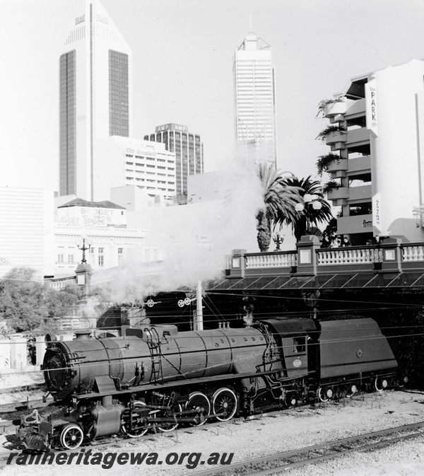 P23429
HVR owned V class 1213 emerging from under the Barrack Street bridge, Perth., City buildings in background. ER line. 
