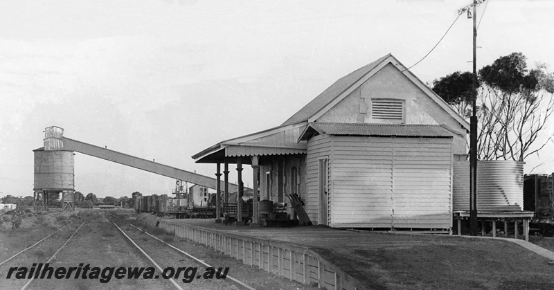 P23436
Station building, telegraph pole, water tanks behind the building,  main line and loading bin in the background. Dongara, MR line. End view of the building
