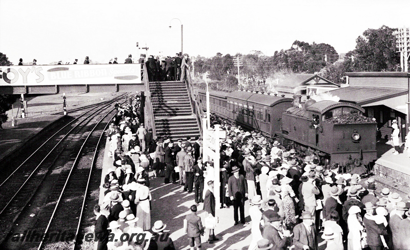 P23444
D type Tank engine, rear end first, on passenger train, platforms, overhead footbridge, crowds for Royal Show, Claremont, ER line, side and end view of locomotive, from elevated position
