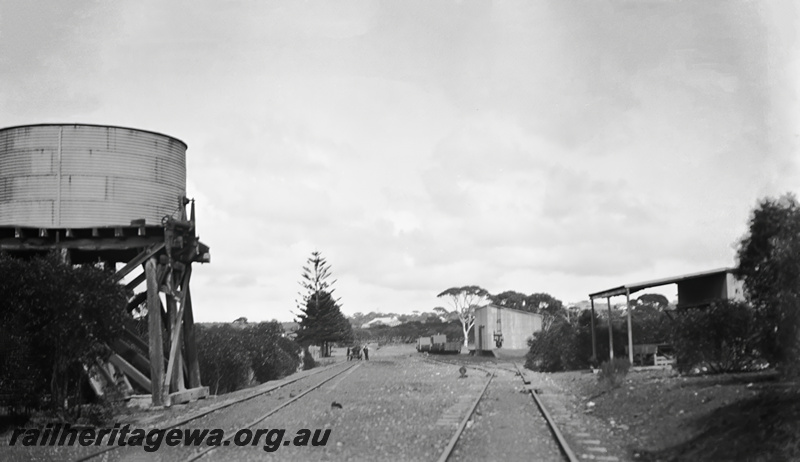 P23448
Water tower with a corrugated iron tank, goods shed, tracks, shelter, Hopetoun, HR line, track level view
