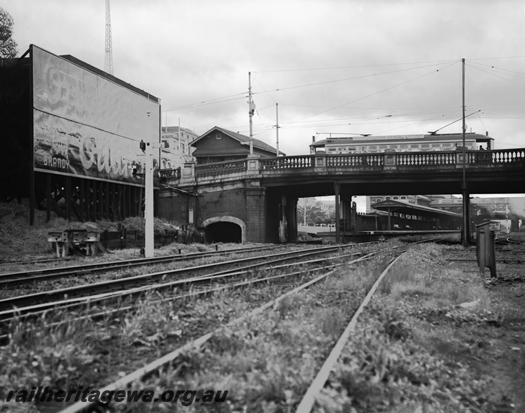 P23481
Tram crossing Barrack St bridge, signal, advertising hoarding, platform, canopy, Perth station ER line, view from trackside
