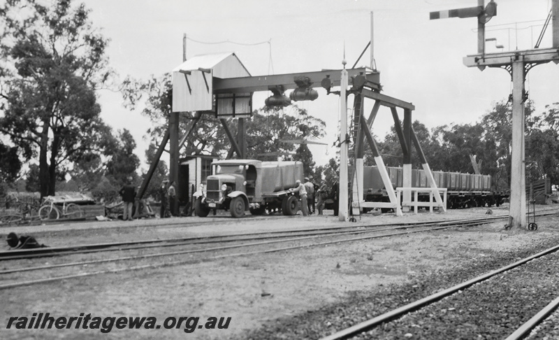 P23513
Gantry, loading a  container on the back of a truck wagon with cement for the construction of Canning Dam, signals, tracks, workers, track level view , Armadale, SWR line. See also P23514 & P23415
