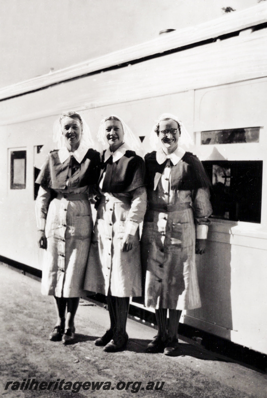 P23520
AQ class carriage, ding WWII, standing in front of the carriage are  Nursing Sisters Mumme, Dawson and Paynter.  
