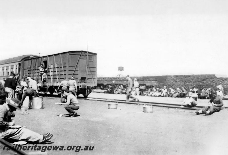 P23532
Meal time on the Nullarbor. The cattle wagon was the kitchen car. Large stew pots from the Wiles Cooker can be seen alongside the track. 
