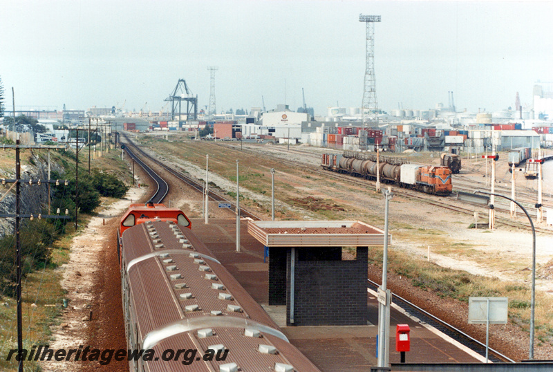 P23567
 A class hauling former Queensland Railway carriages in platform, another A class arriving hauling a train of fuel tankers, Leighton - view from footbridge. ER line 
