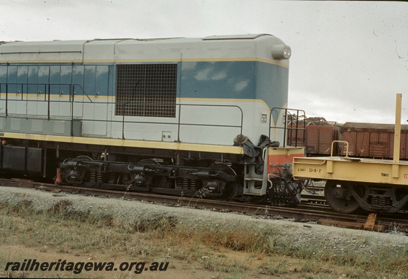 T04675
K class standard gauge diesel locomotive coupled to a WF class flat top wagon. The employee's wet weather equipment is on the front running boards of the loco. T4669.
