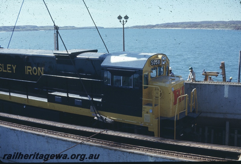 T04772
Hamersley Iron (HI) GE36-7 class 5058 (Goninan-GE) being lifted from vessel MV Iron Baron onto wharf at Dampier.
