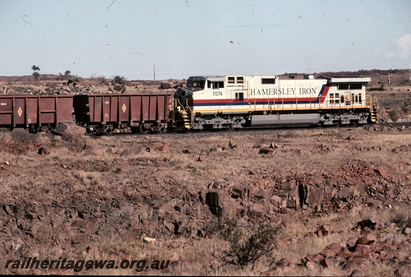 T04811
Hamersley Iron (HI) GE Dash 9-44CW class 7074 pushing ore cars through dumper at Dampier.

