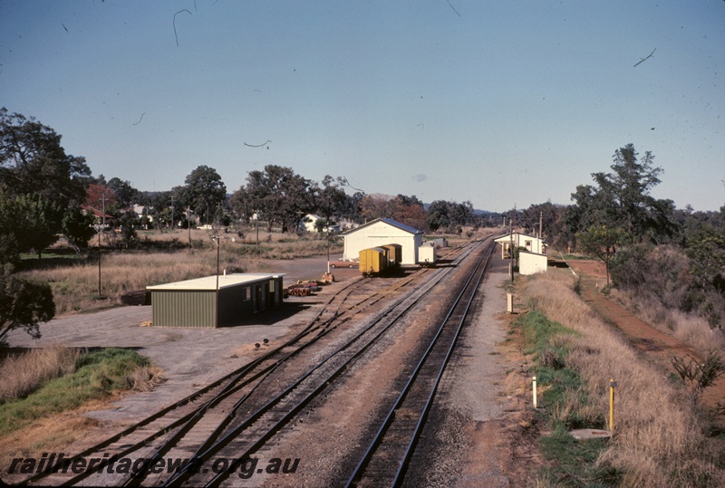 T05095
Station and sidings, points, rake of wagons, trackside building, goods shed, station building, platform, Waroona, SWR line, view from elevated position looking south
