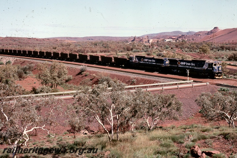 T05168
BHP Iron Ore (BHPIO) distant view of loaded iron ore train at Newman. Mount Newman mine in background.

