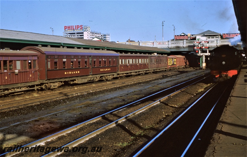 T05438
Scene at Perth station platform 5, train headed by WAGR DD class 600 comprising WAGR V class bogie van with an advertisment for 