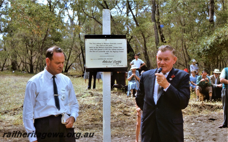 T05462
Plaque erected by Australian Railway Historical Society W.A. Division, marking the point where the railway built in 1871 by the Western Australian Timber Company from its Yoganup Mills to the port of Lockeville, crossed the road, ARHS president, Mr Stan Bishop looks on while the President of the Busselton Shire, Mr Frank Jolliffe adresses the gathering,  Wonnerup 
