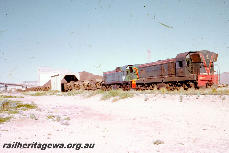 T05509
A class 1506 and 1513 haul a loaded iron ore train through Western Mining's unloading facility at Geraldton. NR line.
