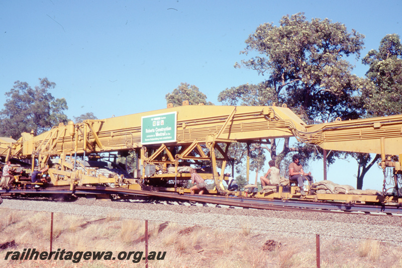 T05786
6 of 8 views of the work on the Kalgoorlie to Kwinana Rehabilitation Project featuring the P811 Track Replacement Machine. Sleepers being place onto the roadbed with workers on the machine.
