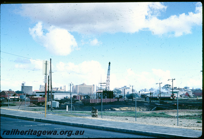 T06223
East Perth Loco Depot, dismantling coal stage at temporary loco depot, QU Class flat wagons, RA Class open wagons, K Class open wagon, steam crane, water column, turntable, city skyline, Claisebrook railcar depot in background, ADA/ADG Class railcar set passing site, photo taken from East Parade
