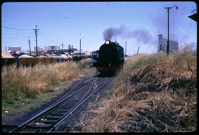 T06608
V Class 1220, departing Bunbury loco depot, unidentified ADF Class Wildflower railcar, Shopper headboard, CBH grain silos, BP fuel tanks, loco bound for Picton Junction for ARHS 75th tour to Donnybrook
