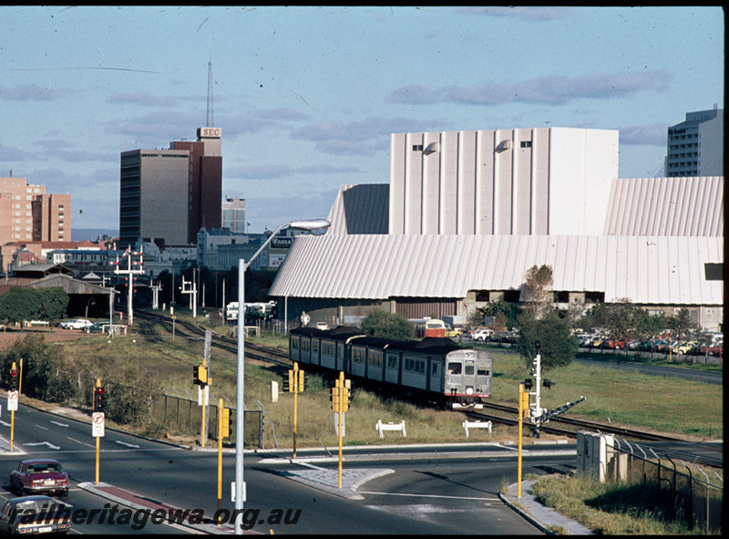 T07450
ADB/ADK/ADB/ADK Class railcar set, Down suburban passenger service, between West Perth and City, busway level crossing, carriage shed, semaphore bracket signal, Perth Entertainment Centre, ER line
