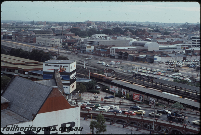 T07933
Overview of City Station and Perth Yard, unidentified DA Class, Up goods train, XN Class hoppers in consist, Horseshoe Bridge, platforms, awning in the process of being re-roofed, Perth Box B signal cabin, semaphore signals, Wellington Bus Station, Perth Entertainment Centre, ER line
