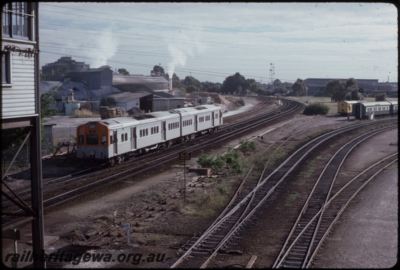 T08270
ADL/ADC Class railcar set, Down suburban passenger service, departing Claisebrook, signal cabin, point rodding, speed sign, zero kilometre peg, carriages stored in old East Perth Power Station exchange sidings, ER line

