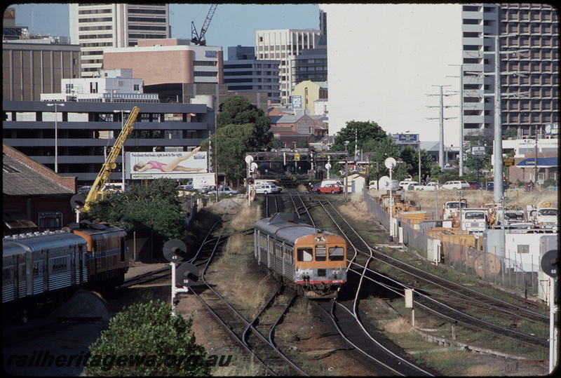 T08312
ADB Class 779 with ADK Class railcar, Down suburban passenger service, approaching Claisebrook, , unidentified XA Class preparing to depart Claisebrook Depot with a 5-car set of hired Queensland Railways (QR) SXV and SX Class carriages, searchlight signals, ER line
