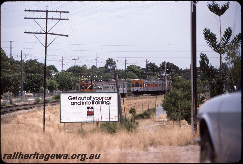 T08613
ADB Class 780 with ADK Class railcar, Down suburban passenger service, ADL Class 802 and ADC Class 852, Up suburban passenger service, between Oats Street and Welshpool, Transperth advert on billboard with slogan 